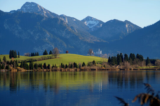 scenic and serene lake Bannwaldsee in Schwangau with the Bavarian Alps in the background on a sunny November day (Allgaeu, Bavaria, Germany)