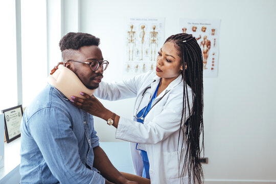 African American man wearing neck brace listening to doctor at hospital. Traumatologist talking to  male patient in cervical collar. Medical interview, professional help, injury treatment