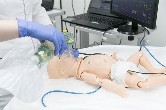 Nurse students resuscitate a child on a mannequin using an ambu bag. Children's dummy for medical students studying at the faculties of medical universities.