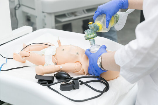 Nurse students resuscitate a child on a mannequin using an ambu bag. Children's dummy for medical students studying at the faculties of medical universities.