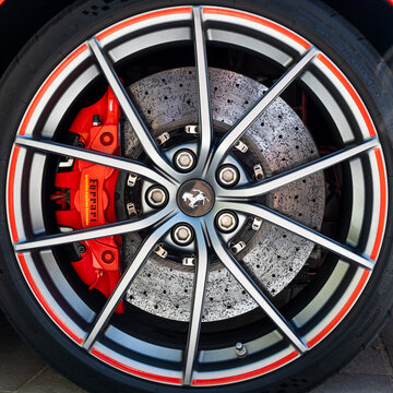 BAYONNE, FRANCE - CIRCA AUGUST 2022: Detail shot of Ferrari alloy wheel and Brembo carbon ceramic brake system with red caliper.