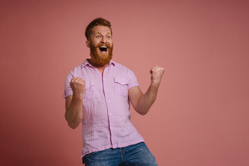 Ginger white man with beard screaming and winner gesture