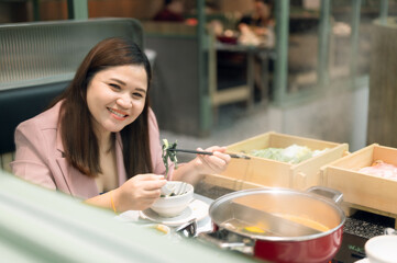 Asian women are happy to eat at the restaurant.
