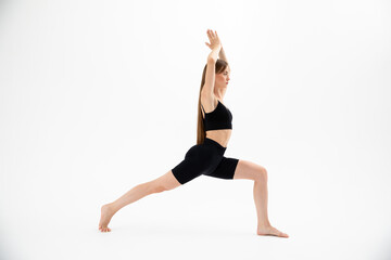 Fototapeta premium Beautiful brunette fitness woman doing yoga on a white background