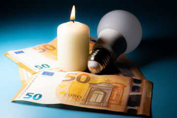 Energy price increase. Burning candles with an incandescent bulb on euro money. Increase in energy bill prices.