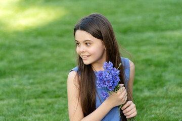 smiling teen girl with flowers. pretty girl on grass. cute girl portrait