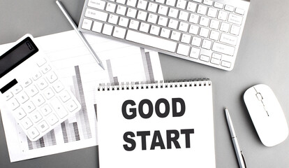 GOOD START text written on notebook on grey background with chart and keyboard, business concept