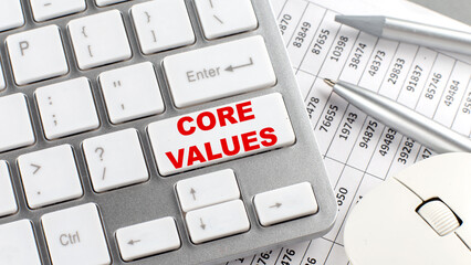 CORE VALUES text on a keyboard wirh chart and pencil