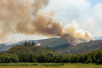 Helicopter against wildfire during strong wind and drought near Miren Castle in Slovenia