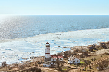 Atmospheric romantic view to white red lighthouse with farm utility houses in Merzhanovo