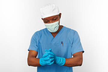 Black surgeon doctor man in blue coat white cap surgeon mask sterilizes blue gloves white background