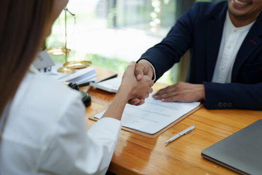 Portrait of a male lawyer shaking hands with a client to settle a court case