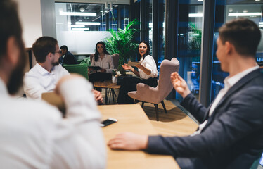 Group of cheerful colleagues communicating in modern office