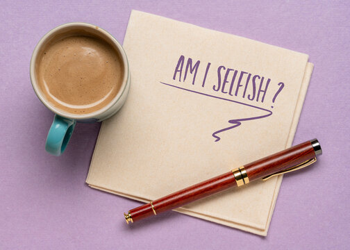 Am I selfish? A question handwritten on a napkin, flat lay with coffee. Concern, self awareness and personal development.