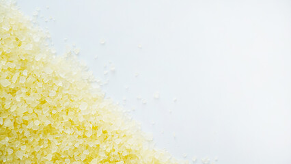 Texture of yellow sea salt crystals on a white background