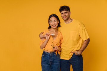 Young multiracial couple reading flower and smiling