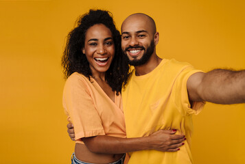 Obraz premium Black young man and woman laughing while taking selfie photo
