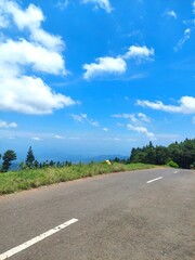a street scene against a bright blue sky background photographed in portrait mode
