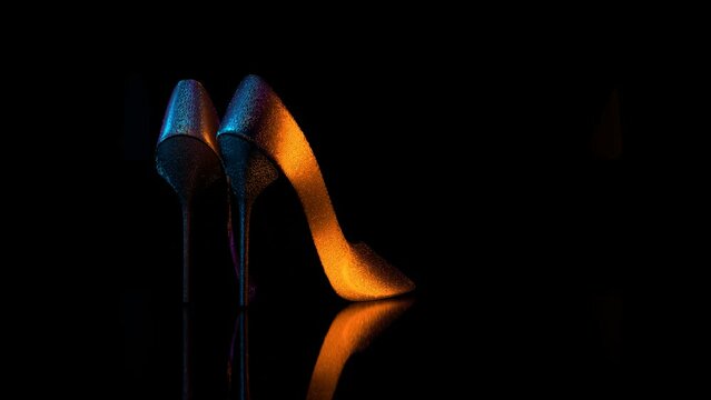 A pair of female shoes spins on black background 3D 4K looped animation with copy space. Footwear store showcase.