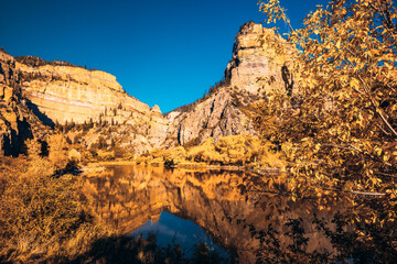 Rocky bluff overlooking mirrored reflection lake in Autumn from Colorado near Glenwood Springs...