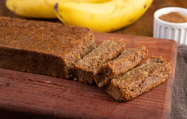 Sliced grains and banana cake over wooden board