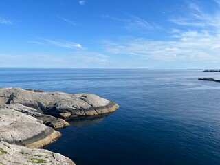 ocean blue horizon, ocean surface, rocky coastline of the fjord