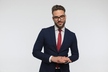 unshaved businessman with glasses touching hands and rubbing palms