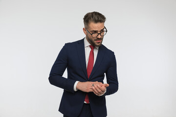 sexy man with glasses wearing elegant suit and rubbing palms