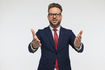 bearded businessman with glasses gesticulating and showing with hands