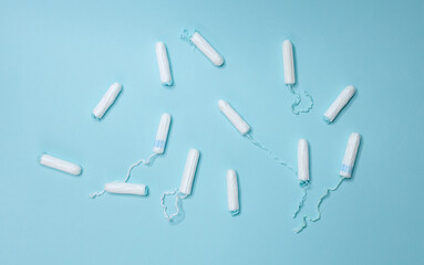 Various sanitary tampons lie on a light blue background. Menstrual cycle and pregnancy.