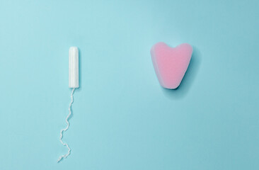 Various sanitary tampons lie on a light blue background. Menstrual cycle and pregnancy.