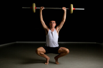 Naklejka premium Nineteen year old teen boy exercising with a barbell