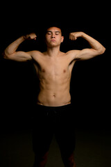 Fototapeta na wymiar Nineteen year old teen boy flexing his arm muscles