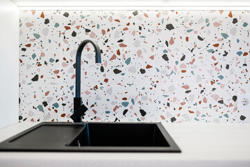 Black, marble hand-washing for kitchen with colored tiles