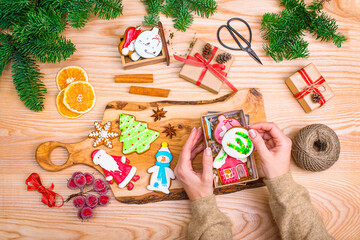 Woman packing Christmas gingerbread cookies. Handmade Christmas presents.