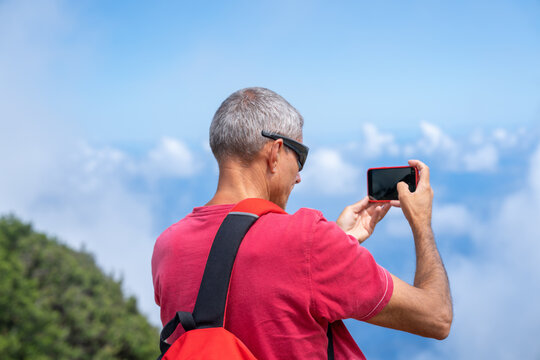 Man taking pictures of beautiful mountain scenario