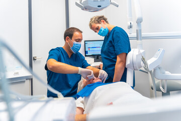 Dental clinic, dentist doctor and assistant examining the teeth of an elderly woman lying on the table