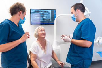 Dental clinic, dentist doctor and assistant explaining to an elderly woman dental treatment, denture