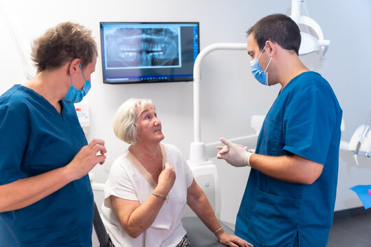 Dental clinic, dentist doctor explaining to elderly woman dental treatment, denture