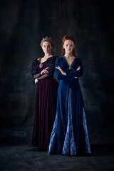 Portrait of two beautiful women in image of queen and princess isolated over dark background. Royal family © Lustre Art Group 