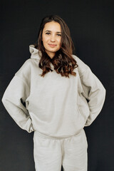 Attractive sexy woman wear warm total look. Girl look preaty. Elegant look. Brunette model wear hoody. Winter, fall autumn or spring minimal outfit. Woman is sensual.
