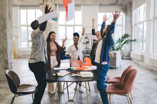 Cheerful diverse colleagues celebrating victory in office