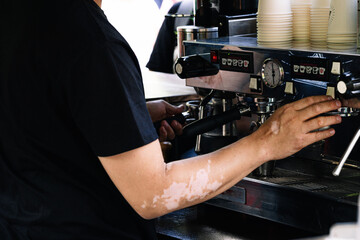 Cropped view of barman in apron preparing coffee with coffee machine
