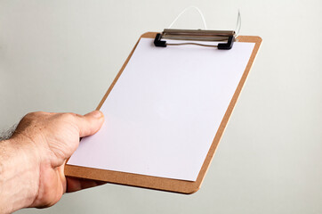 notepad with copy space in the hands of caucasian man, gray-green background