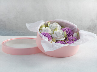 Fototapeta na wymiar Zephyr bouquet of flowers in a gift box on a light background, Valentine's Day