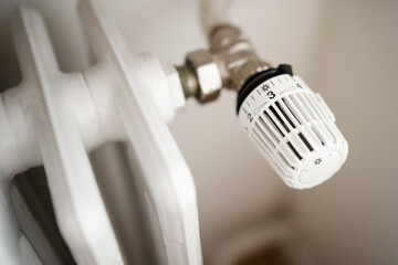 Rising heating costs in a crisis: people adjust the temperature in the house using a heating...