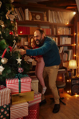 Obraz na płótnie Canvas Little helper with father decorating Christmas tree
