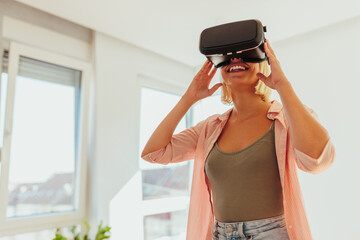Fototapeta na wymiar Woman using augmented reality headset at home.