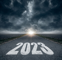 2023 written on highway road in the middle of asphalt road and dark cloudy sky. Future vision 2023