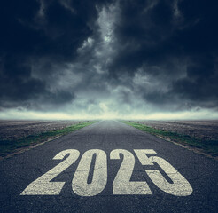 2025 written on highway road in the middle of asphalt road and dark cloudy sky. Future vision 2025